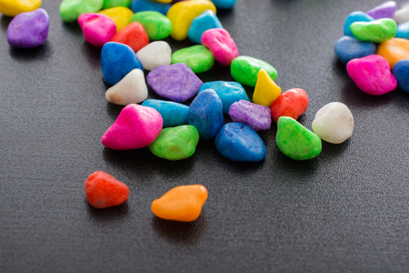 Pile of little colorful pebbles on black backgroundの写真素材
