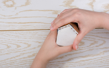 Little model housein hand on a parquet backgroundの写真素材