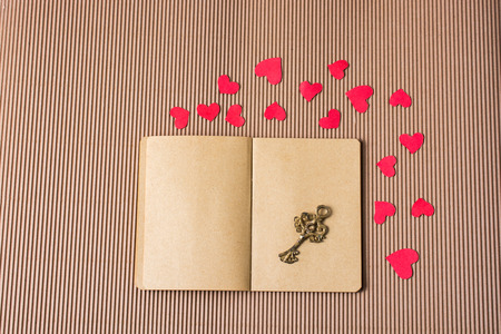 paper hearts around notebook with a decorative retro keyの写真素材