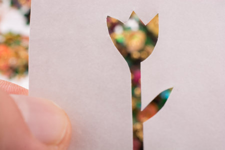 Tulip shape cut out of a paper with a colorful background