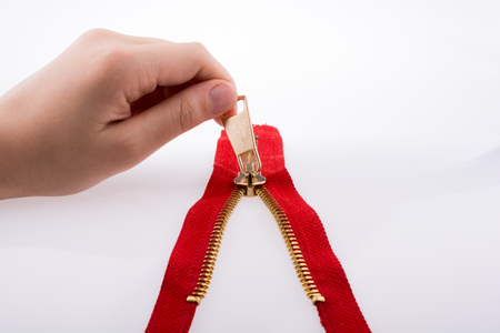 Hand holding color zipper on a white backgroundの写真素材