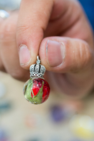 ball shaped pendant with flower petal inside resinの写真素材