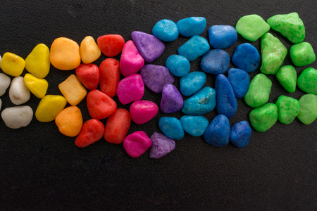 Pile of little colorful pebbles on black backgroundの写真素材