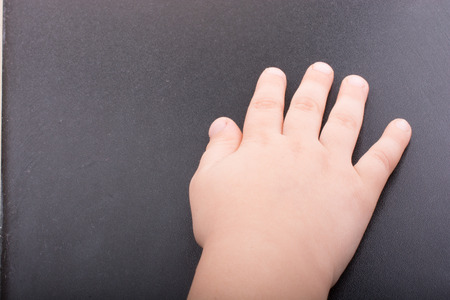 Toddler hand with dark color backgroundの写真素材