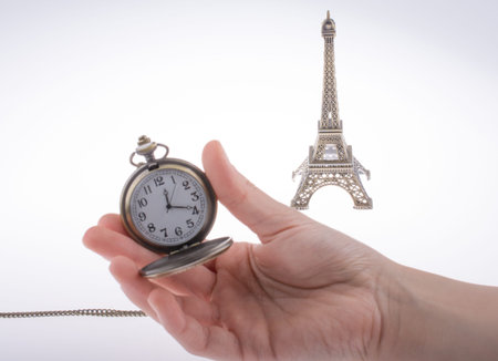 Hand holding a pocket watch befere Eifel Towerの写真素材