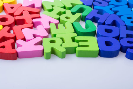 Colorful alphabet letter blocks scattered randomly on white background