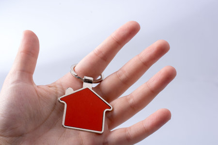 Real estate concept with a metal house icon in hand