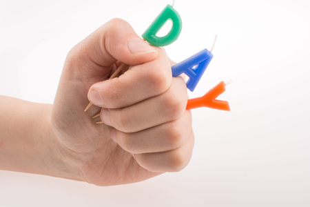 Color candles on sticks in hand write the word dayの写真素材