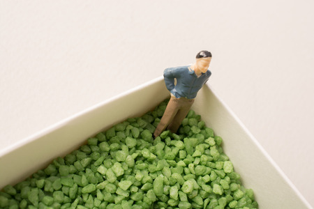 Tiny figurine of man miniature in green sand textureの写真素材