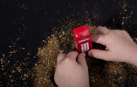 Hand holding a phone booth on a brown backgroundの写真素材