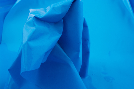 Crumpled paper put in water in blue backgroundの写真素材