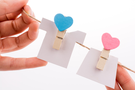 Hearted clothespins hanging on a thin ropeの写真素材