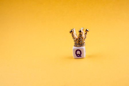 Crown on letter cube on a yellow backgroundの写真素材