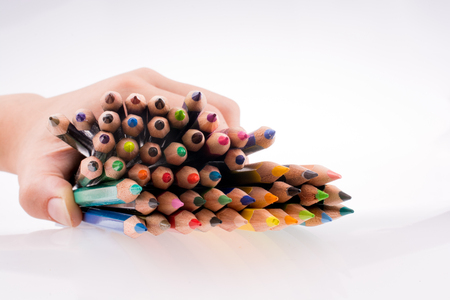 Hand holding Color pencils on a white backgroundの写真素材