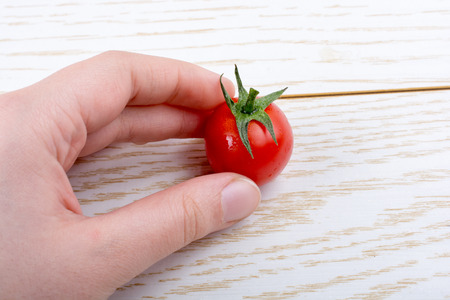 Red ripe tasty fresh cherry tomato in hand in viewの写真素材