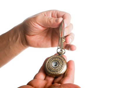 Hand holding a retro styled metal pocket watch in hand on a white backgroundの写真素材