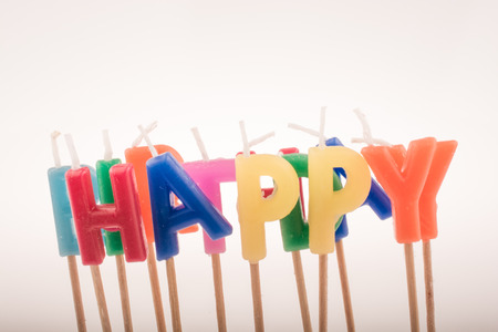Color candles on sticks write the word happyの写真素材