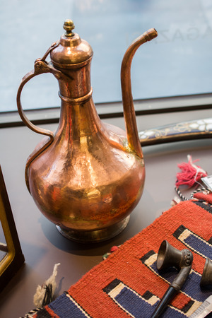 Ancient metal jug in oriental style  in antique marketの写真素材