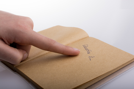 Hand pointing 'Education is...' on a notebookの写真素材