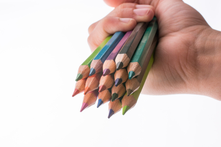 Hand holding color pencils on a white backgroundの写真素材
