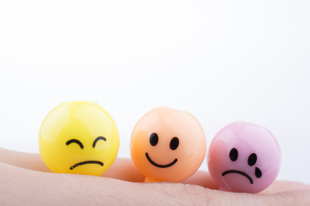 Hand holding Color beads with facial expression on white backgroundの写真素材