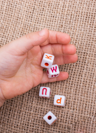 Colorful alphabet letter cubes in handon a  canvas backgroundの写真素材