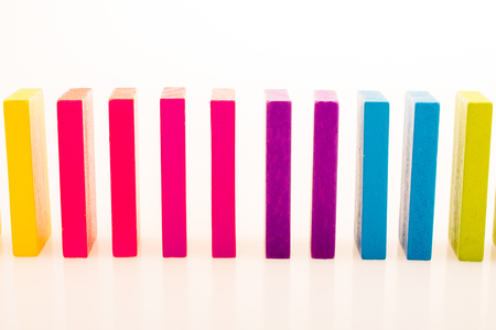 Colorful Domino Blocks in a line on a white backgroundの写真素材