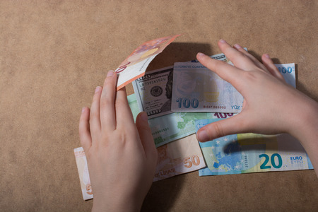Hand holding American dollar  banknotes isolated on wooden backgroundの写真素材