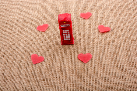 Red hearts around red colour phone booth on canvasの写真素材