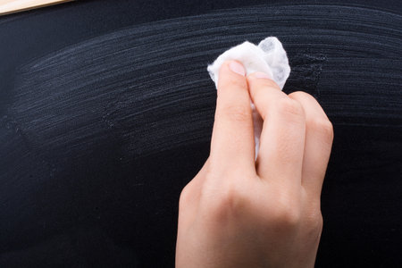 Hand cleaning blackboard on a white background