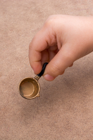 Hand holding a little model pan as a kitchen utensilの写真素材