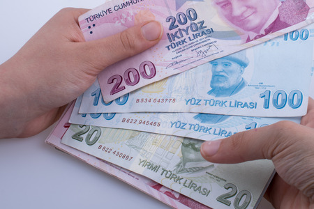 Hand holding Turksh Lira banknotes  on white backgroundの写真素材