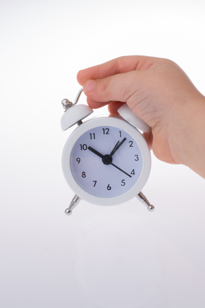 Child  holding an alarm clock  k on white backgroundの写真素材