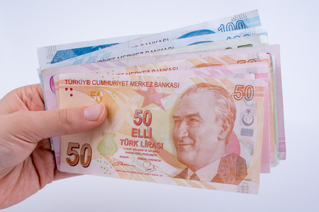 Hand holding Turksh Lira banknotes  on white backgroundの写真素材