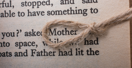 Thread tied  as knot on a light colour backgroundの写真素材