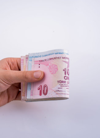 Hand holding Turksh Lira banknotes  on white backgroundの写真素材