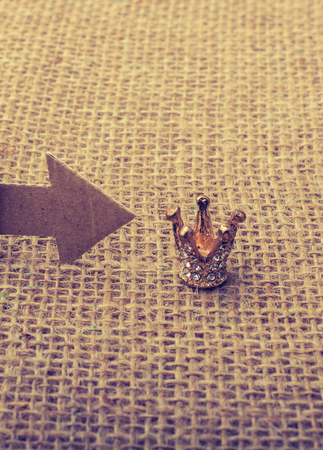 Figurine man led by an arrow to a crown on canvasの写真素材