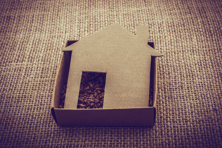 Little house shape cut out of paper on a canvas backgroundの写真素材