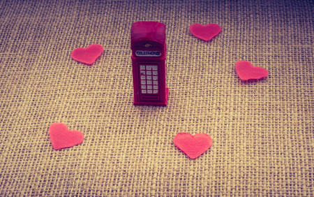 Red hearts around red color phone booth on canvasの写真素材