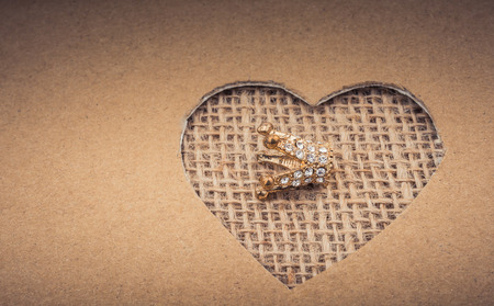 Crown seen through heart shape cut out of cardboardの写真素材