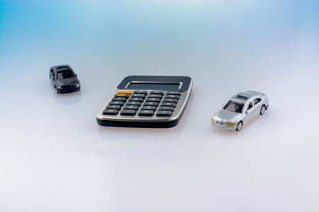 Calculator and Toy cars as a transportation devices on backgroundの写真素材