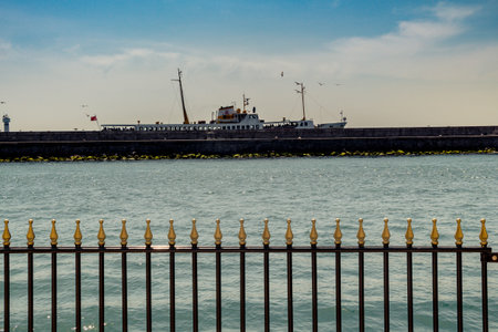 Part of decorative colorful metal fence and a boat behind
