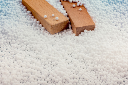 Wooden blocks in White polystyrene foam balls as backgroundの写真素材