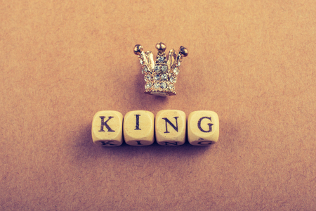 Tiny model crown beside the king wording on brownの写真素材