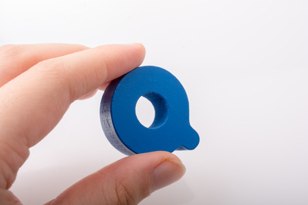 Hand holding letter cube Q of made of woodの写真素材
