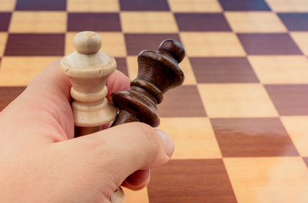 Person playing chess game making a move on boardの写真素材