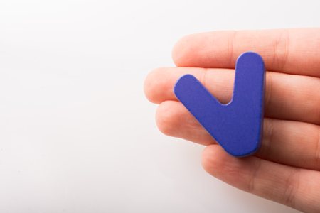 Hand holding letter cube V of made of woodの写真素材