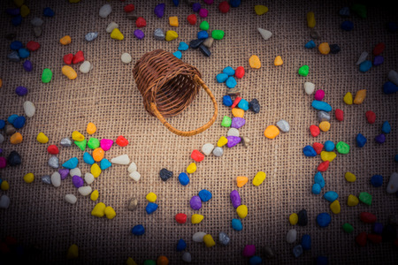Basket and spilled  pebbles on canvas backgroundの写真素材