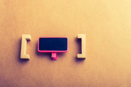Mini size  notice board made of wood between bracketsの写真素材