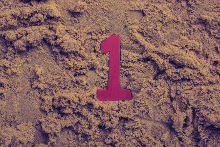 Wooden number 1 one on brown sand backgroundの写真素材